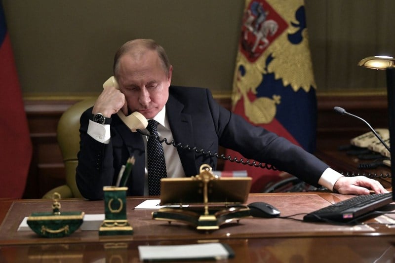 Russian President Vladimir Putin speaks on the phone in his office in Saint Petersburg.