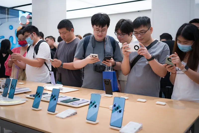 Customers try out smartphones at a Huawei flagship store in Shanghai on Sept. 3.