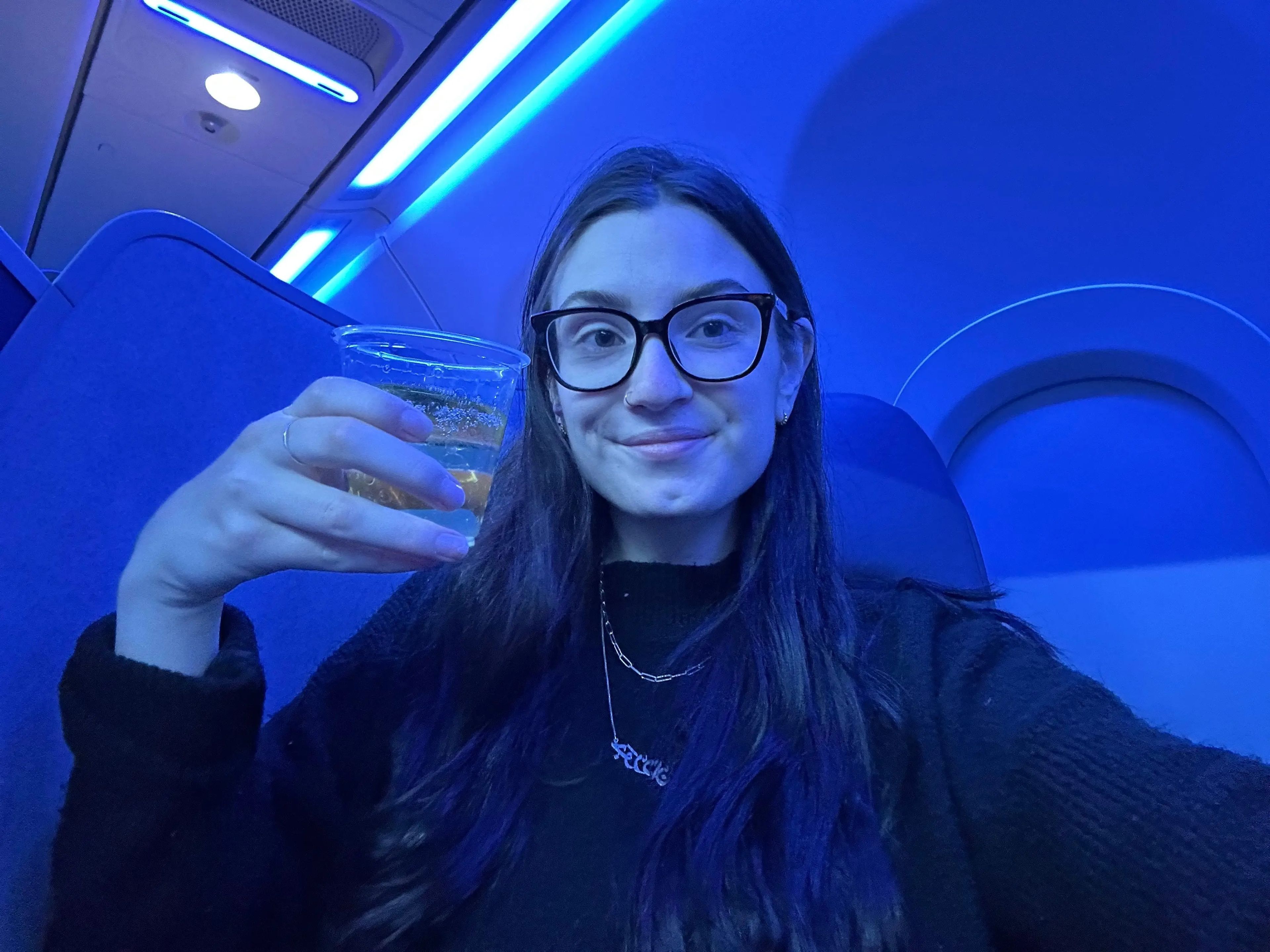 Insider's reporter smiles for a selfie holding a glass of champagne.