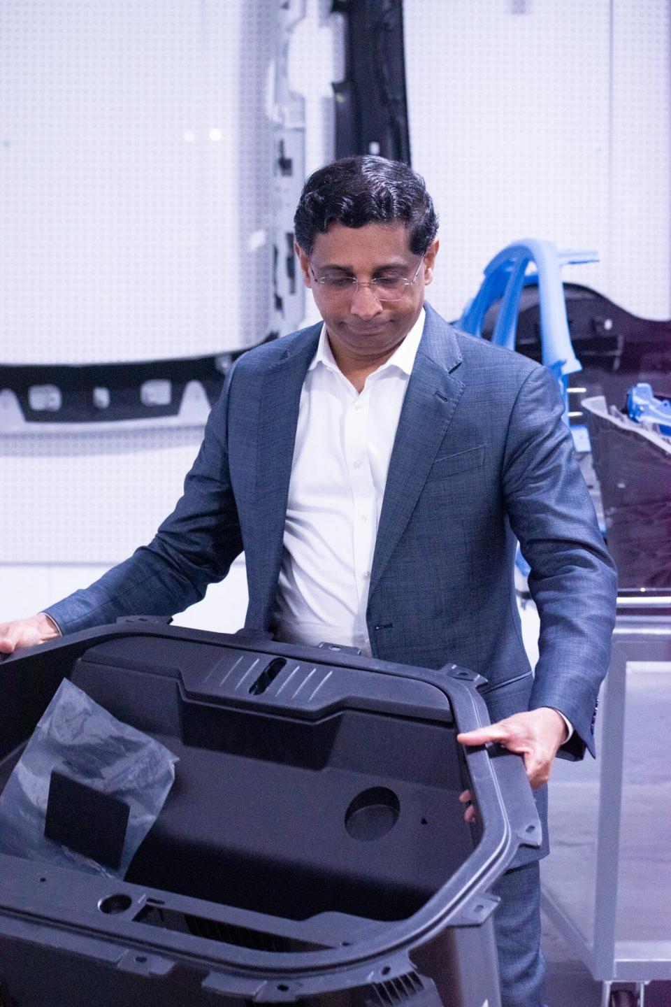 Caresoft CEO Mathew Vachaparampil shows how a Tesla Model Y frunk snaps into place using just five pieces. Tesla and other startups, including in China, are unimpeded by century-old methods of vehicle development.